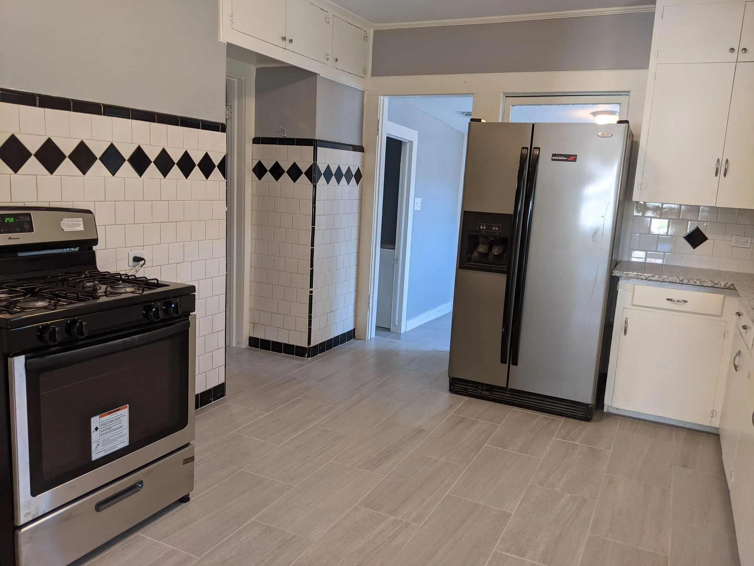 Renovated kitchen with diamond-pattern tile and stainless appliances