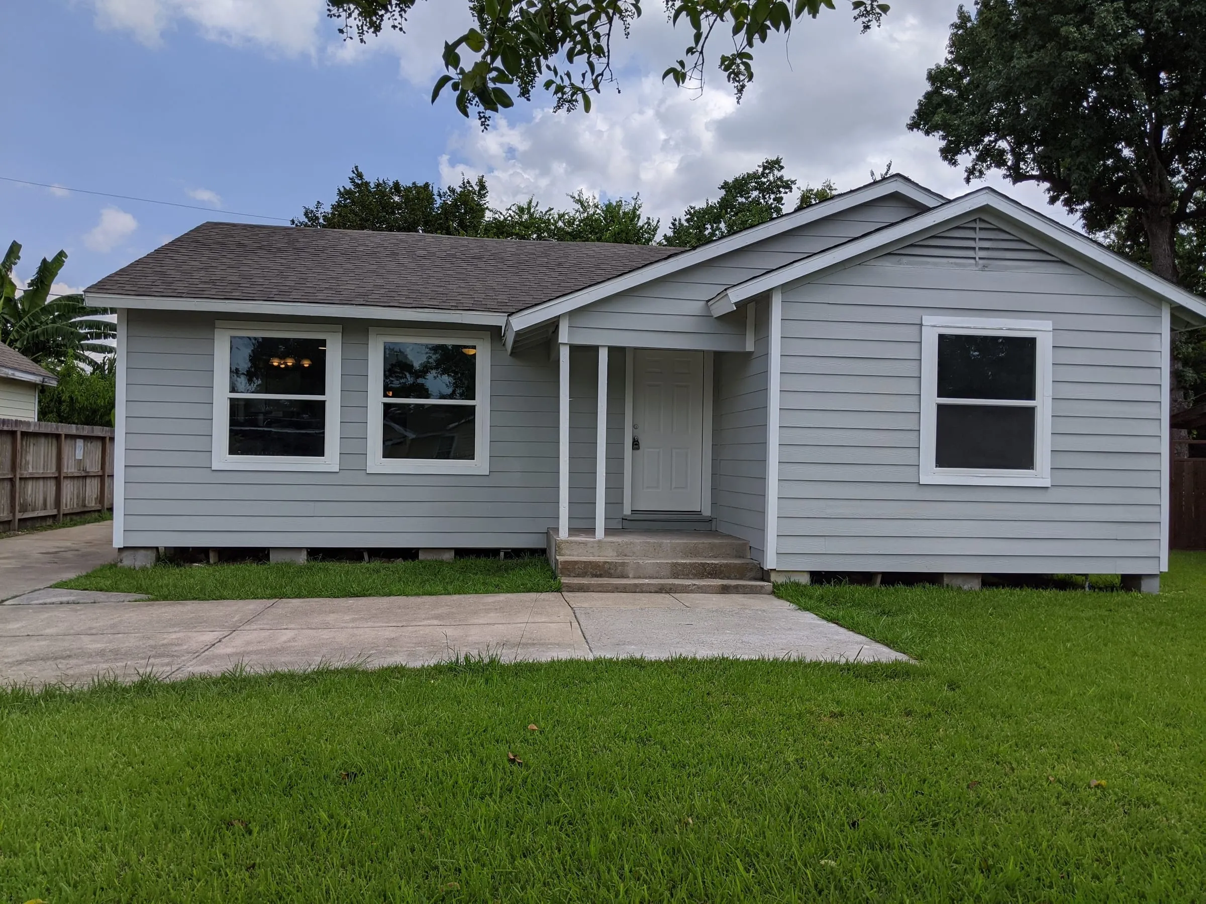 Renovated light-gray single-story house with a new lawn