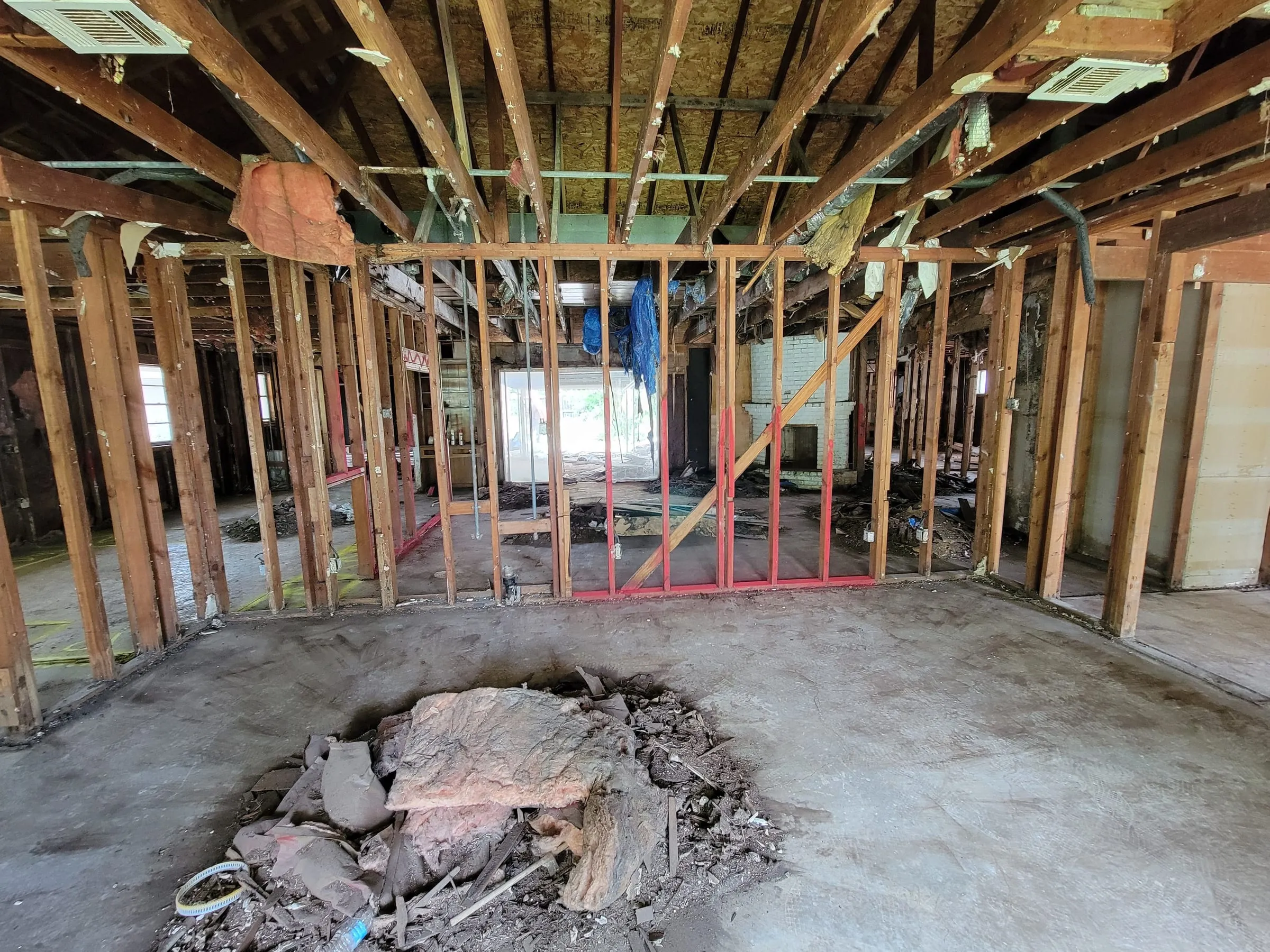 Interior stripped to framing with a trench cut in the slab for plumbing