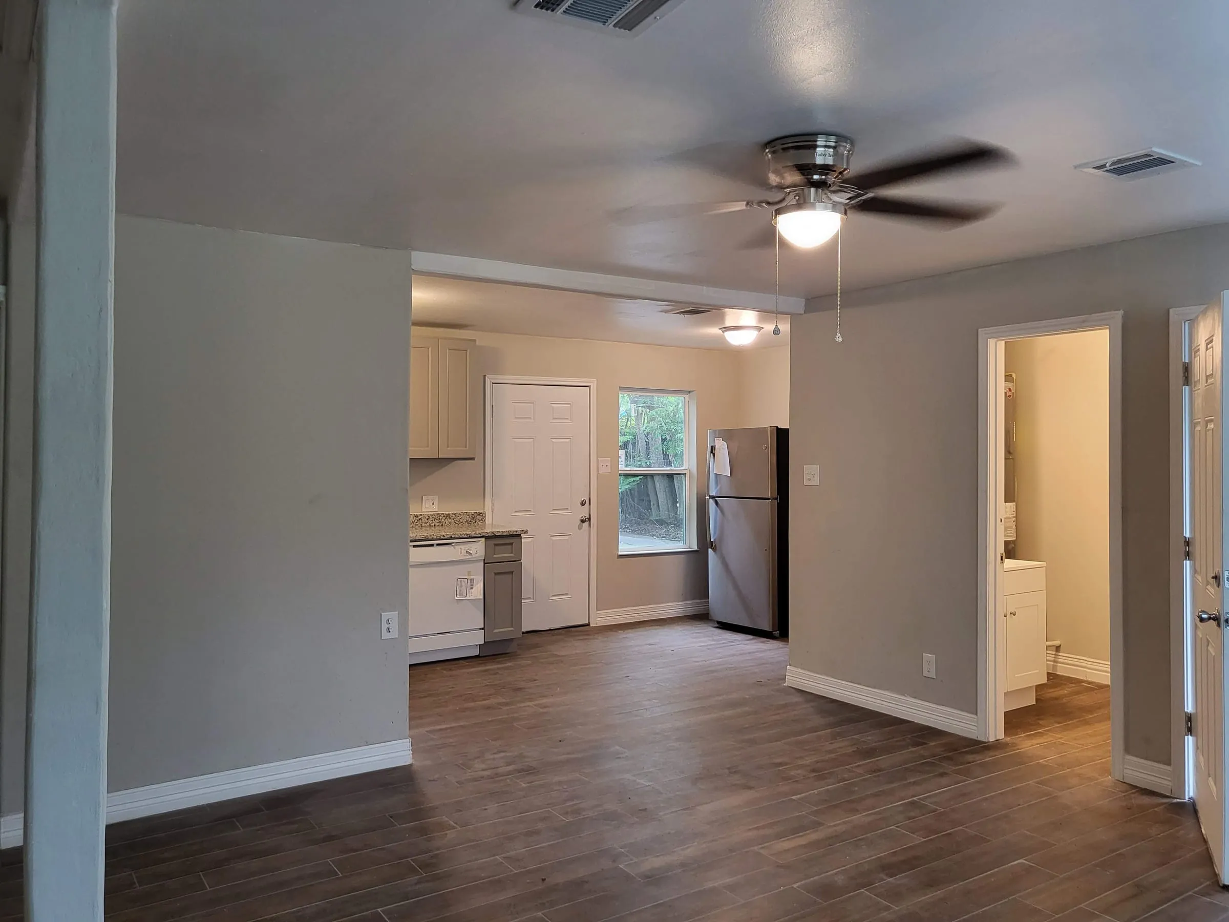 Renovated open living area with gray walls and wood-look floors